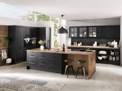 Bild einer schwarzen Landhausküche mit Sitzplatz und einer Arbeitsfläche aus Holz
